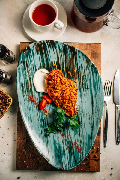 Lezzetli kızarmış et ve ekşi krema soslu vişneli domates ve bir fincan çay ve çaydanlık ile maydanoz. 