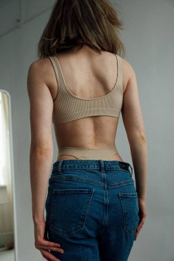 Spor iç çamaşırı giyen ve ışık stüdyosunda poz veren kadın modelin arka plan görüntüsü. 