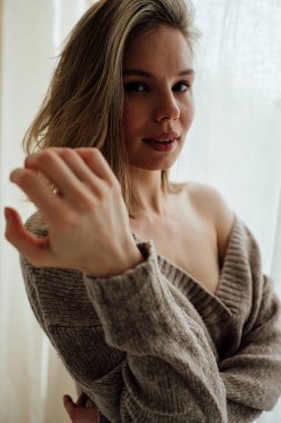 Stüdyoda poz veren kalın kazak giyen güzel bir kız. 