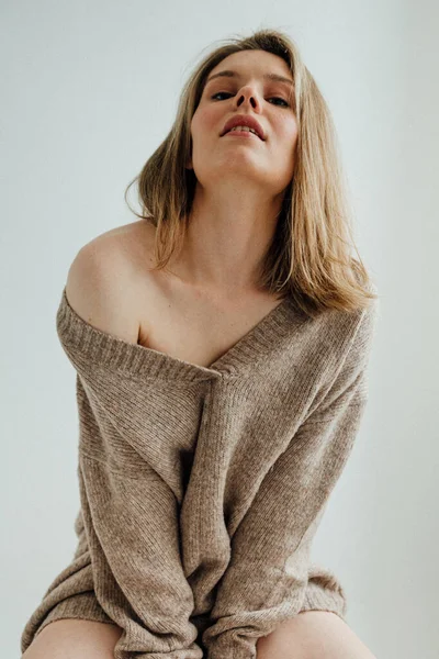 美しい女の子身に着けている暖かいセーターポーズでライトスタジオ — ストック写真