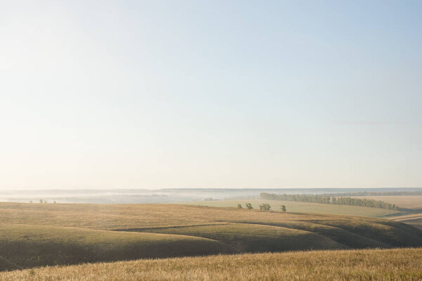 Landscape of early autumn with hills, fields, trees.