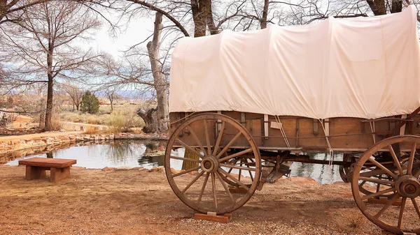 Wagon couvert se trouve à côté de l'eau de source naturelle — Photo