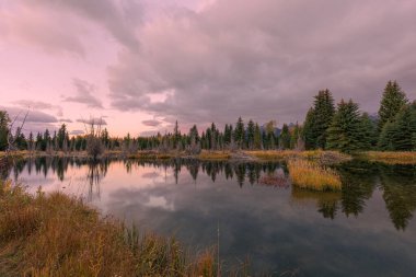 Grand Teton Ulusal Parkı Wyoming 'de sonbaharda günbatımının manzaralı yansıması.