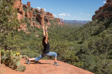 Sedona Arizona 'nın kırmızı kayalarında yoga yapan bir kadın.