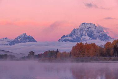Sonbaharda tetonların manzaralı bir gündoğumu yansıması.