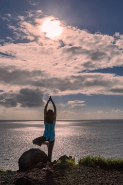 Maui Hawaii sahilinde yoga yapan bir kadın.