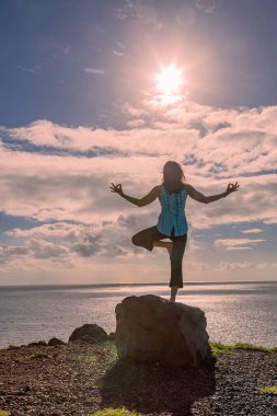 Maui Hawaii sahilinde yoga yapan bir kadın.