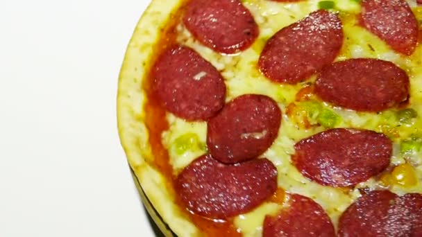 Leckere Pizza dreht sich langsam auf weißem Hintergrund, rechte Einstellung — Stockvideo