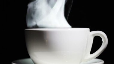 Fincan çay ya da kahve siyah arka plan üzerine Buhar ile. Ağır çekim yakın çekim