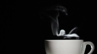 Çay veya kahve hareketi ile siyah arka plan üzerine Buhar ile