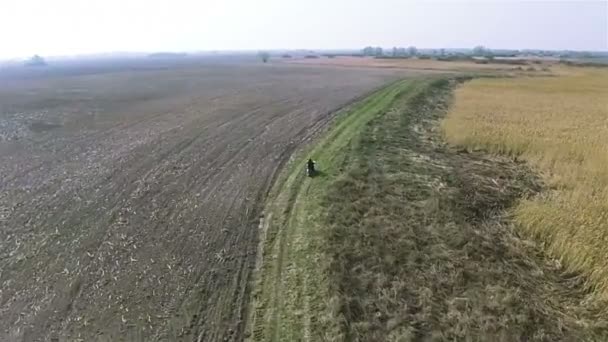 汚れ田舎道、ハメ撮りに行くバイク。空中 — ストック動画
