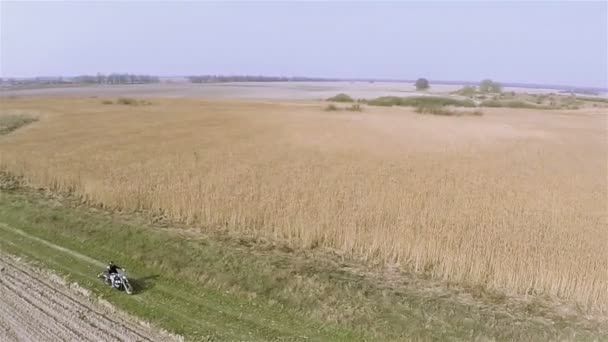 Vuelo alrededor de la motocicleta en la tierra camino rural, vista POV. Antena — Vídeos de Stock