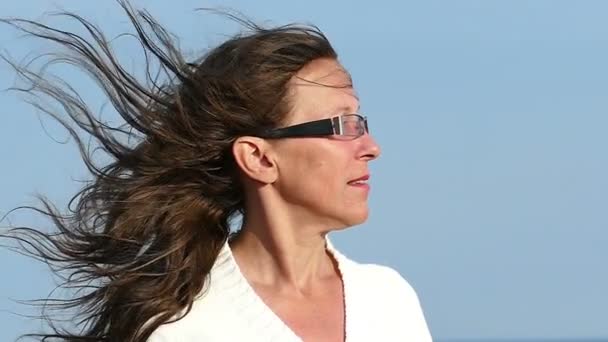 En cámara lenta. Rostro de mujer adulta en gafas con pelo volador — Vídeo de stock