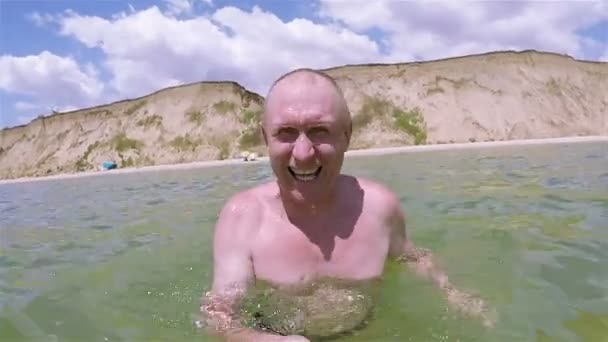 Человек отдыхает на море, снимает селфи с улыбкой и подписать все хорошо — стоковое видео