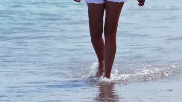 Movimento lento. pernas femininas ir na costa do mar de verão entre as ondas — Vídeo de Stock