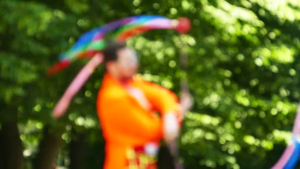 Slow motion. Smiling juggler in city park. Blurred scene — Stock Video