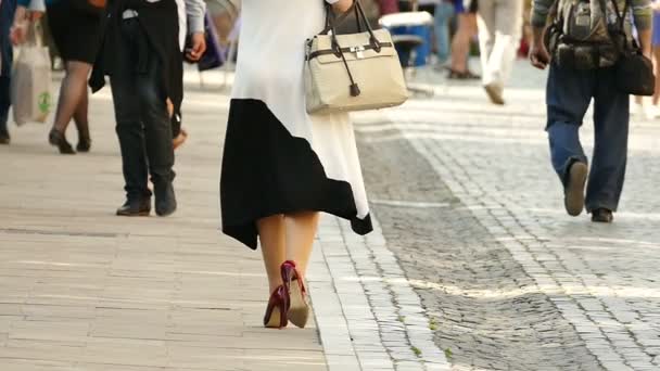 Медленное движение. Город в летний день. Ноги женщины на высоком красном каблуке — стоковое видео