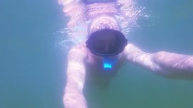 Adamın yüzü maskeli su altında yüzen