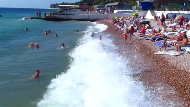 People bathe in waves on a beach — Stock Video