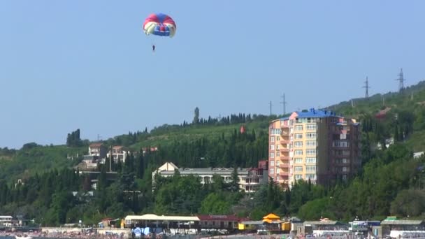 Parachute over de nederzetting — Stockvideo
