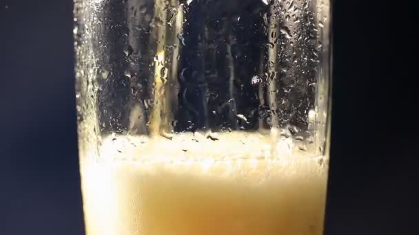 La bière coule autour d'un verre avec des bulles 