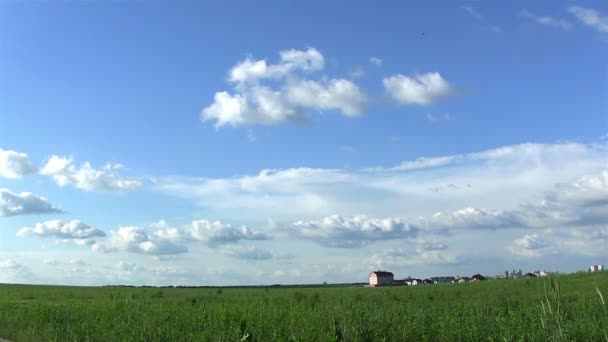 Nuvens sobre o campo com a casa. Prazo de validade — Vídeo de Stock