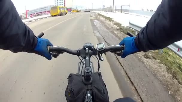 Велосипедист быстро едет по зимней дороге в городе — стоковое видео