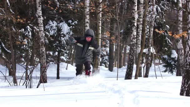 El invierno. El hombre corre sobre nieve profunda. Movimiento lento — Vídeo de stock