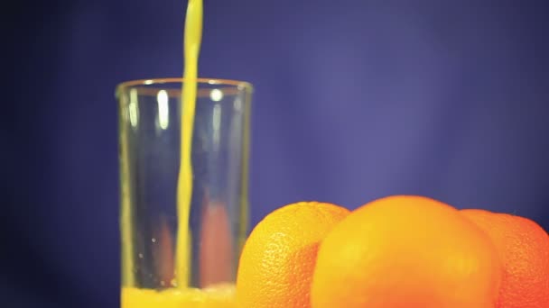 Three oranges and  juice which is pouring in  glass — Stock Video