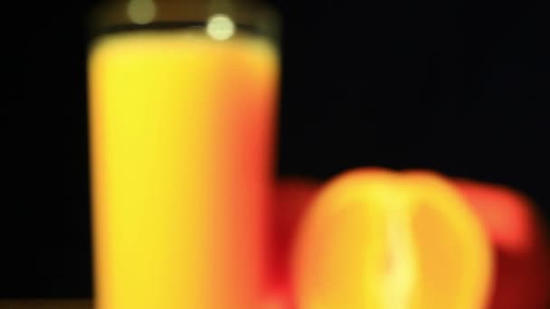 Апельсины и сок, который наливается в стекло — стоковое видео