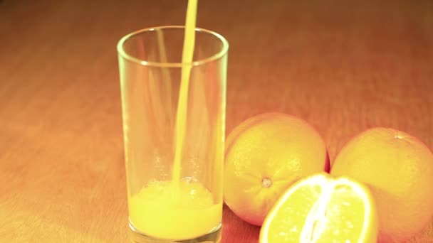 Apelsiner och juice som är hälla i glas — Stockvideo