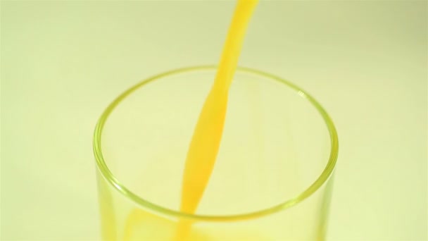 Le jus d'orange coule dans un verre gros plan 