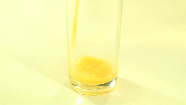 Jus d'orange brillant coulant dans un verre gros plan — Video