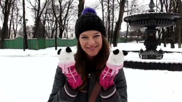 Молода дівчина грає і посміхається в зимовому парку — стокове відео