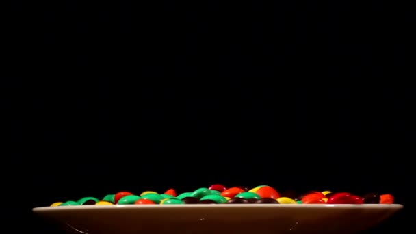 Multi-colored bright candies on a white plate — Stock Video