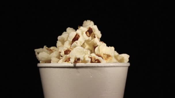 De witte glas met popcorn draait dicht omhoog — Stockvideo