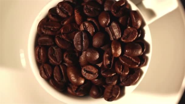 White cup with a saucer and coffee grains close up. Top view — Stock Video