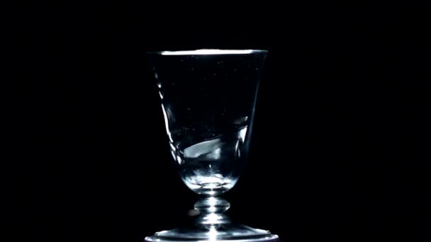 白想玻璃旋转在黑色的背景 — 图库视频影像