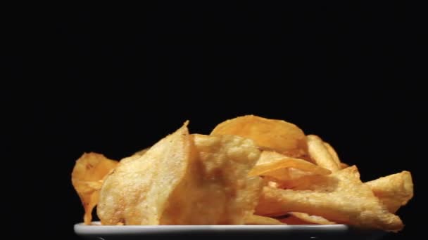 Potato chips in rotatie op een witte plaat — Stockvideo