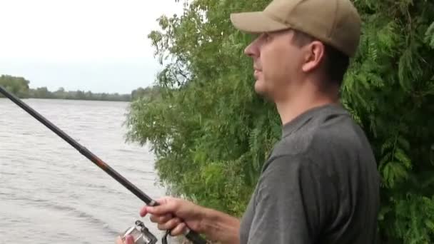 川岸の近くで釣りをする男、餌を投げる — ストック動画
