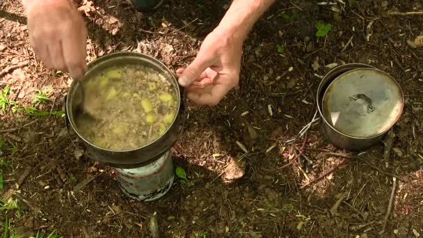 Abendessen auf einer Fackel. Menschenhände rühren Suppe um, Tourismus — Stockvideo
