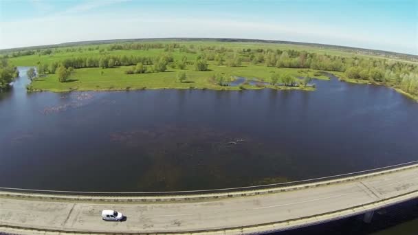 White car on  bridge through  bright beautiful river .Aerial — Stock Video