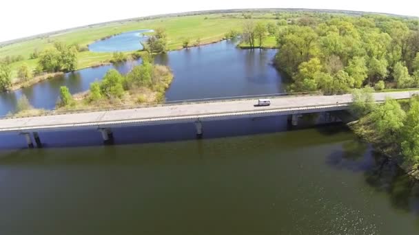 Повільний політ над річкою з мостом у світлий весняний день. Повітряні — стокове відео