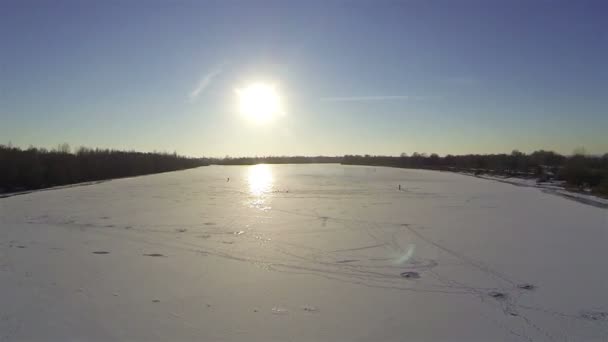 Vuelo sobre el río congelado en invierno con hermoso sol. Antena — Vídeo de stock