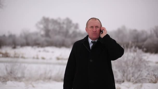 Hombre de negocios tomar buenas noticias en el móvil. Retrato de invierno — Vídeos de Stock
