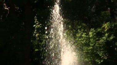 Çeşme su ile güneş ışığı altında su sıçramalarına. Odak Değiştir