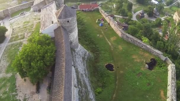 Flight over old fortress with silhouettes of tourists. Aerial shot — Stock Video