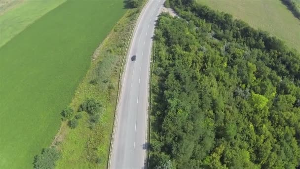 Silnice s automobily a zelenými poli. Letecký záběr pohled shora — Stock video
