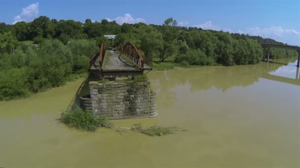 Voar lentamente sobre o rio lamacento com ponte destruída. Tiro aéreo — Vídeo de Stock