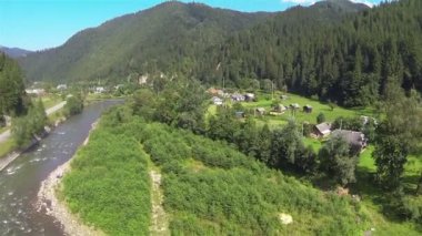 Nehir ve dağ bölgesinde köy üzerinde uçuş. Hava atışı